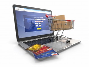 E-commerce. Shopping cart and credit cards on laptop
